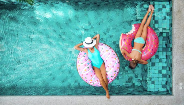 Women on Donut Floaties in Swimming Pool